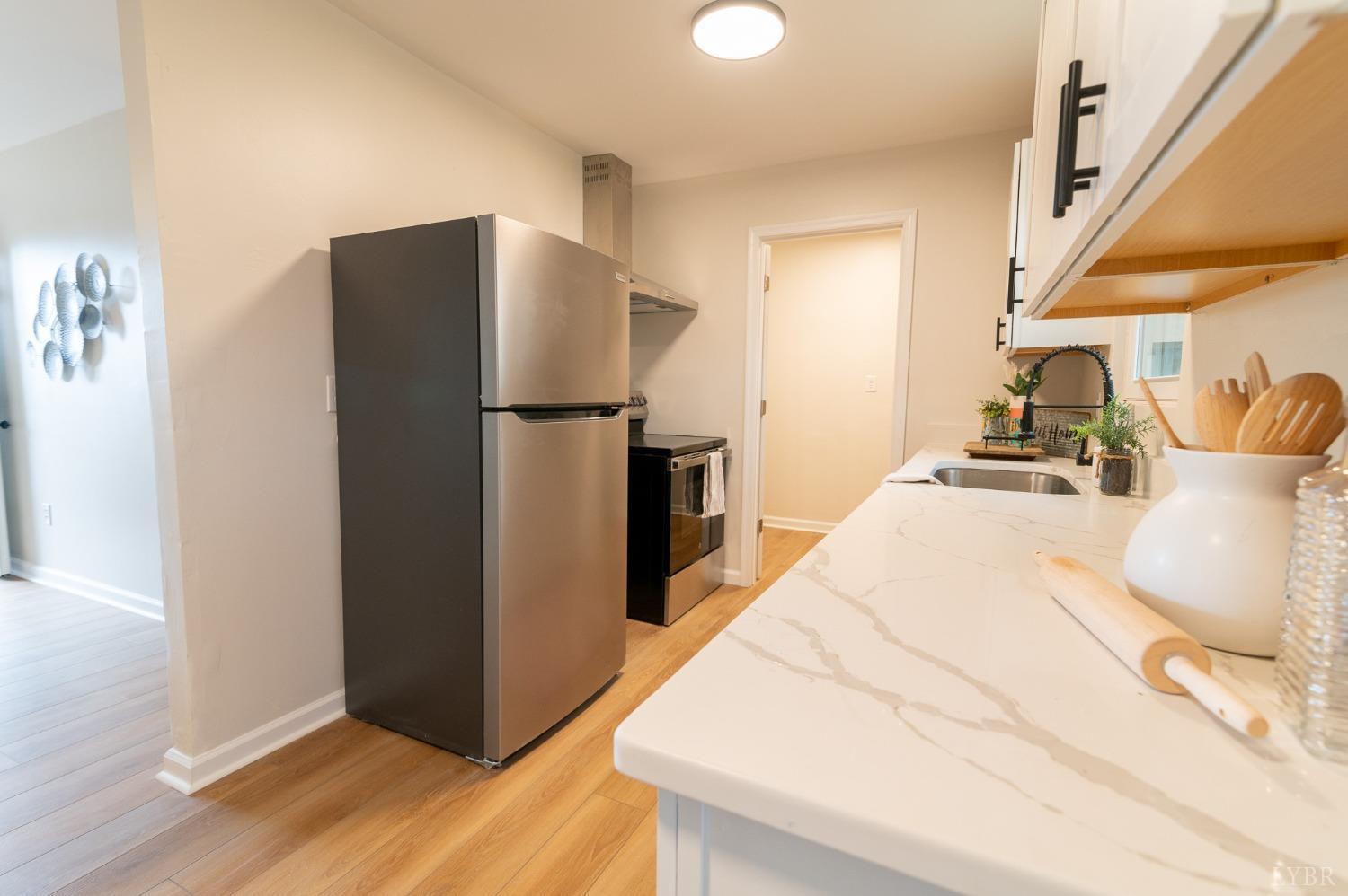419 Robinson Road Appomattox, VA 24522 - Photo 7 of 19 a kitchen with stainless steel appliances a refrigerator and wooden floor