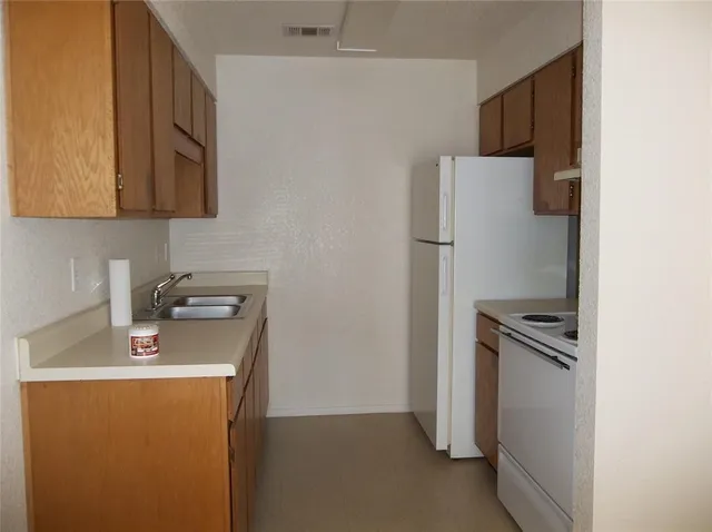 a kitchen with a refrigerator sink and stove