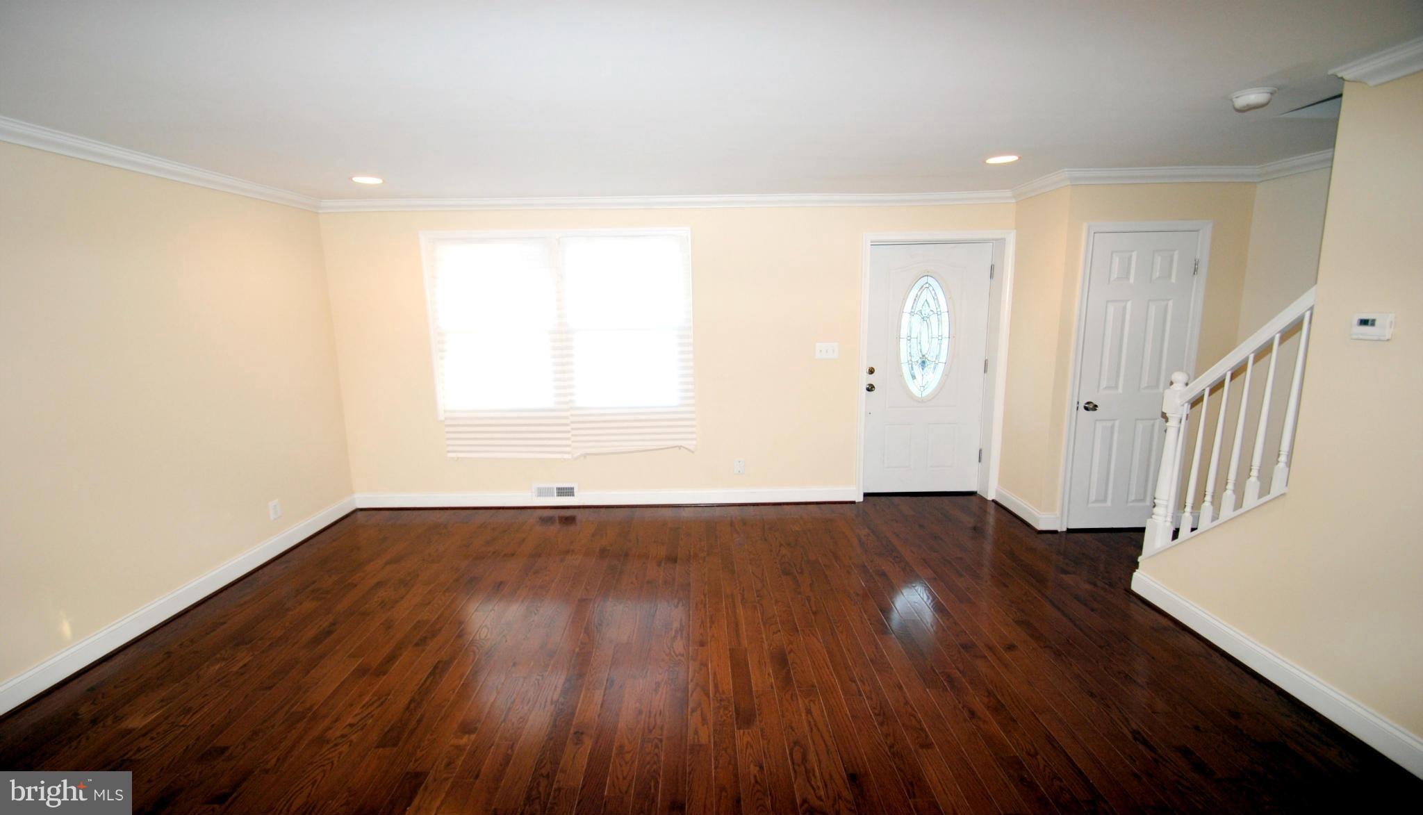 1730 Ingram Road Baltimore, MD 21239 - Photo 3 of 30 an empty room with wooden floor and windows