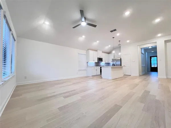 an open space with kitchen view and a refrigerator