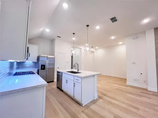 a kitchen with a stove a refrigerator and a sink