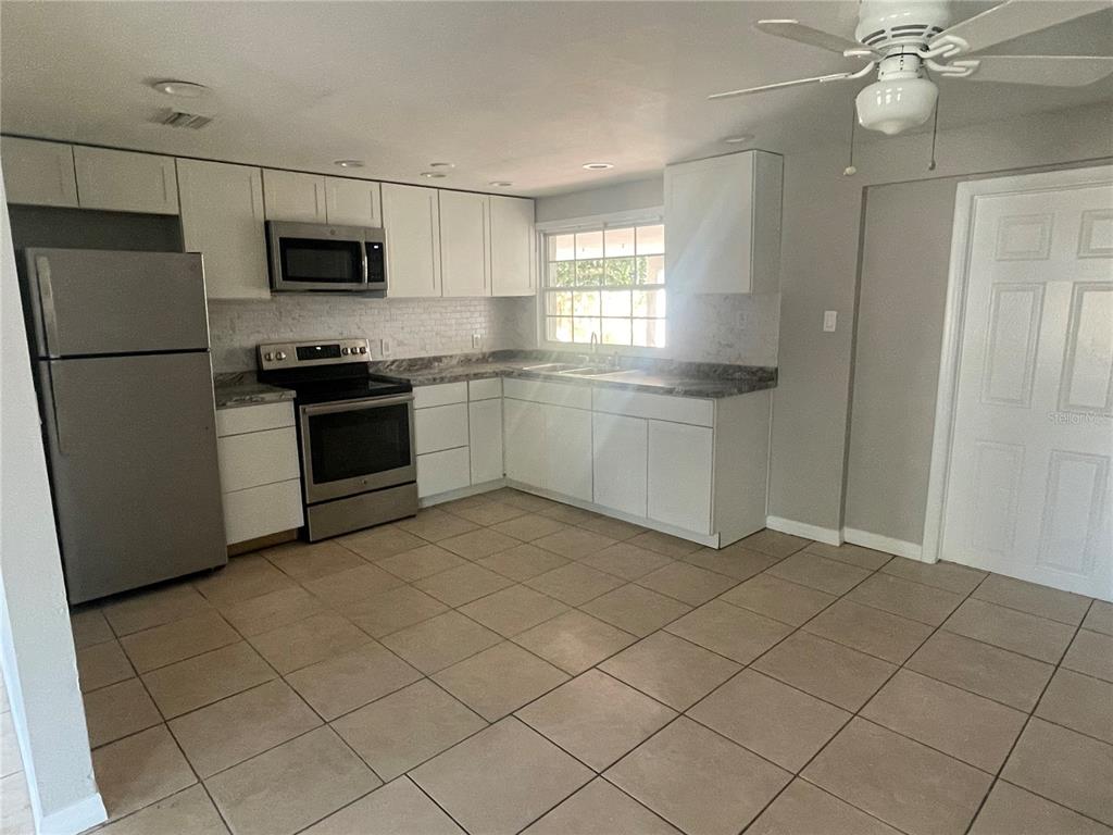 6746 Old Main Street New Port Richey, FL 34653 - Photo 12 of 39 a kitchen with stainless steel appliances a refrigerator sink and microwave