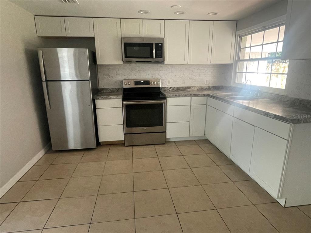 6746 Old Main Street New Port Richey, FL 34653 - Photo 14 of 39 a kitchen with a stove a refrigerator and a sink