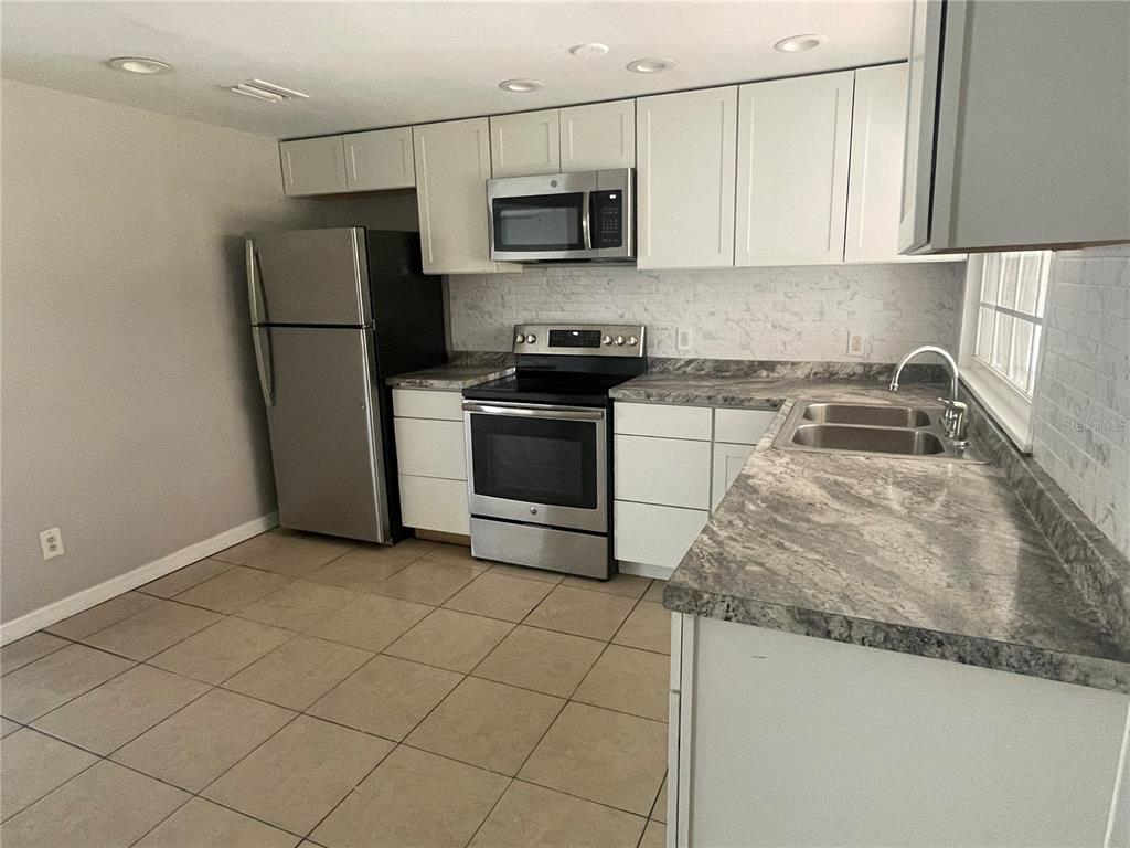 6746 Old Main Street New Port Richey, FL 34653 - Photo 15 of 39 a kitchen with granite countertop a refrigerator and a sink