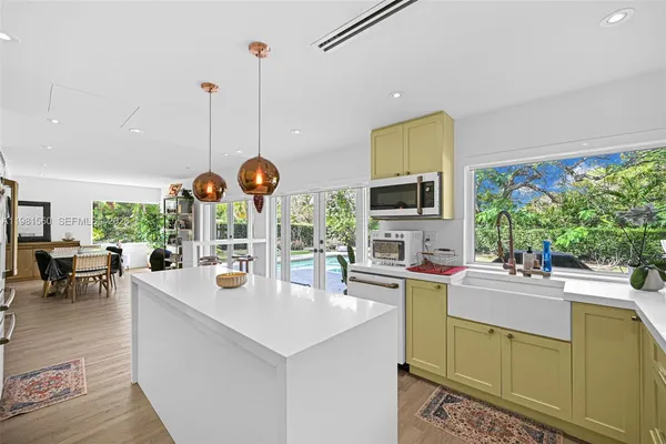 a kitchen with stainless steel appliances kitchen island granite countertop a refrigerator and a stove top oven
