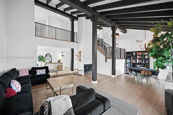 a view of a livingroom with furniture staircase wooden floor and fan