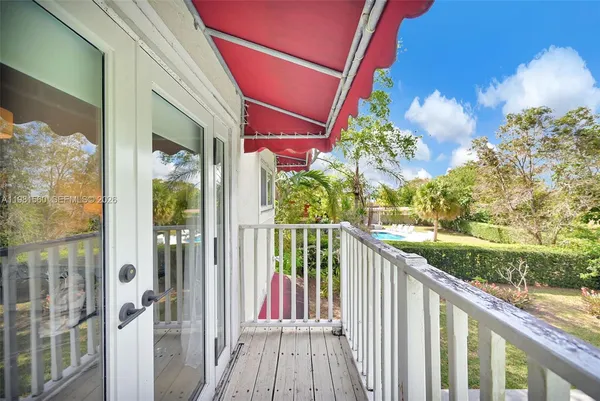 a view of a white building with a swimming pool and sitting area