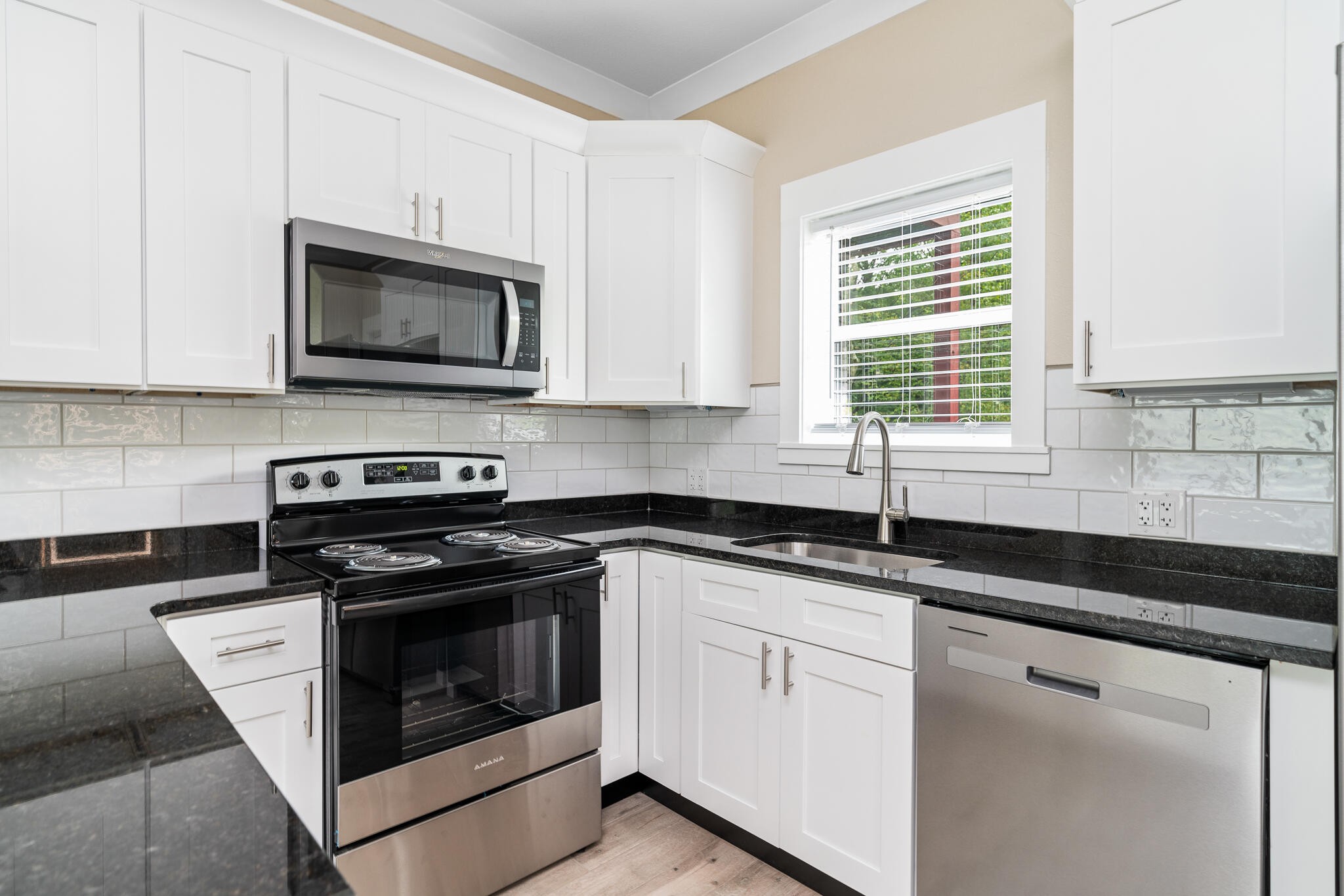 123 Englewood Road Athens, TN 37303 - Photo 39 of 62 a kitchen with granite countertop white cabinets and black stainless steel appliances