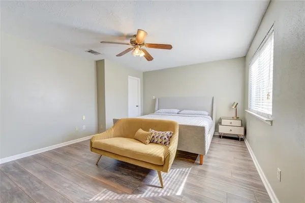 a bedroom with a bed and wooden floor