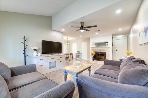 a living room with furniture a flat screen tv and a fireplace