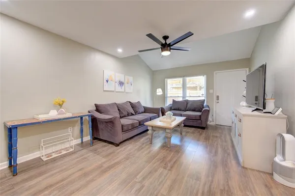 a living room with furniture and a wooden floor