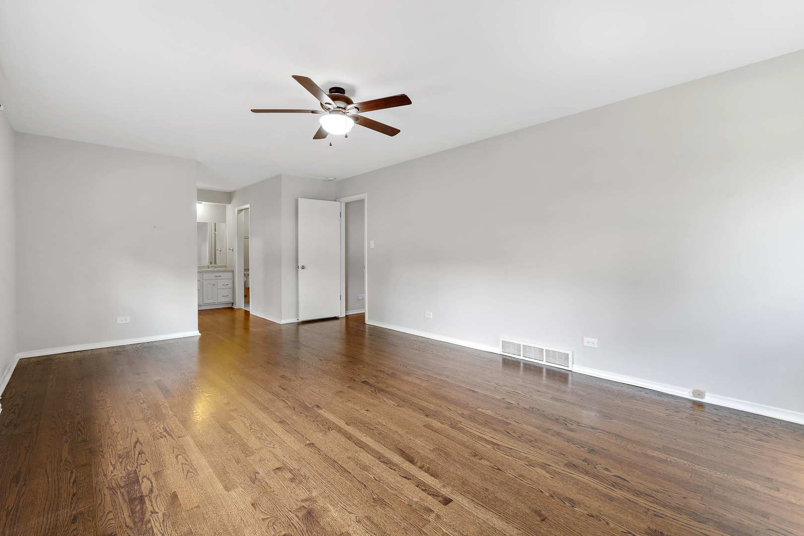 1524 Pfingsten Road Glenview, IL 60025 - Photo 15 of 26 a view of an empty room with wooden floor and a ceiling fan