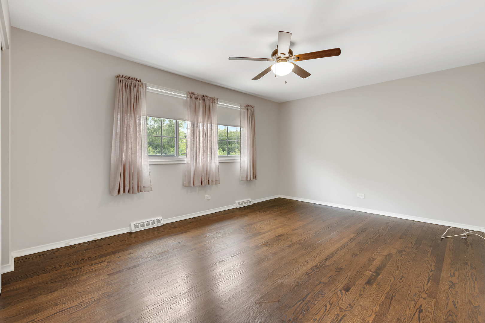 1524 Pfingsten Road Glenview, IL 60025 - Photo 19 of 26 an empty room with wooden floor fan and windows