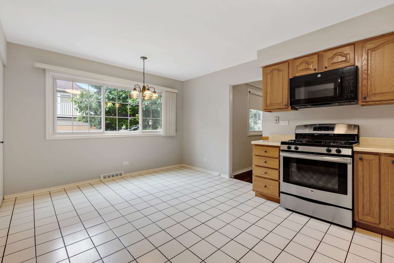 1524 Pfingsten Road Glenview, IL 60025 - Photo 9 of 26 a kitchen with stainless steel appliances a stove a microwave and white cabinets