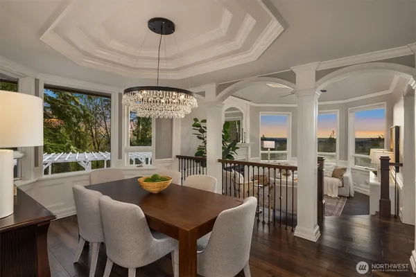 a kitchen with granite countertop a stove a sink a refrigerator and chairs