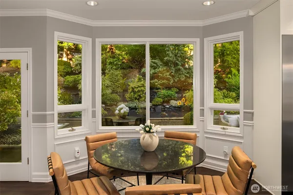a dining room with furniture a large window and wooden floor