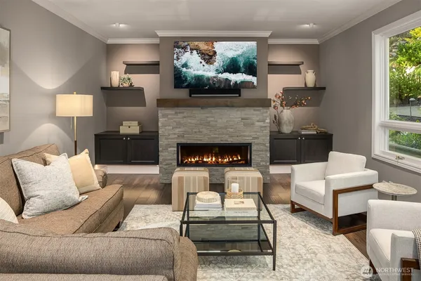 a living room with furniture fireplace and a large window