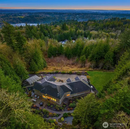 a view of a house with a lush green forest