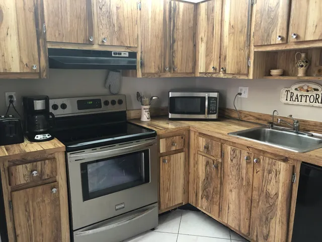 a kitchen with granite countertop a stove sink and cabinets