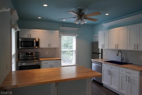 a kitchen with stainless steel appliances a sink stove and refrigerator