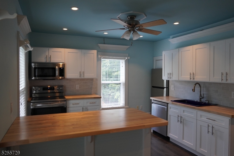 a kitchen with stainless steel appliances a sink stove and refrigerator