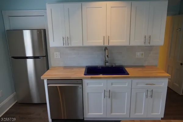 a kitchen with a sink a refrigerator and cabinets