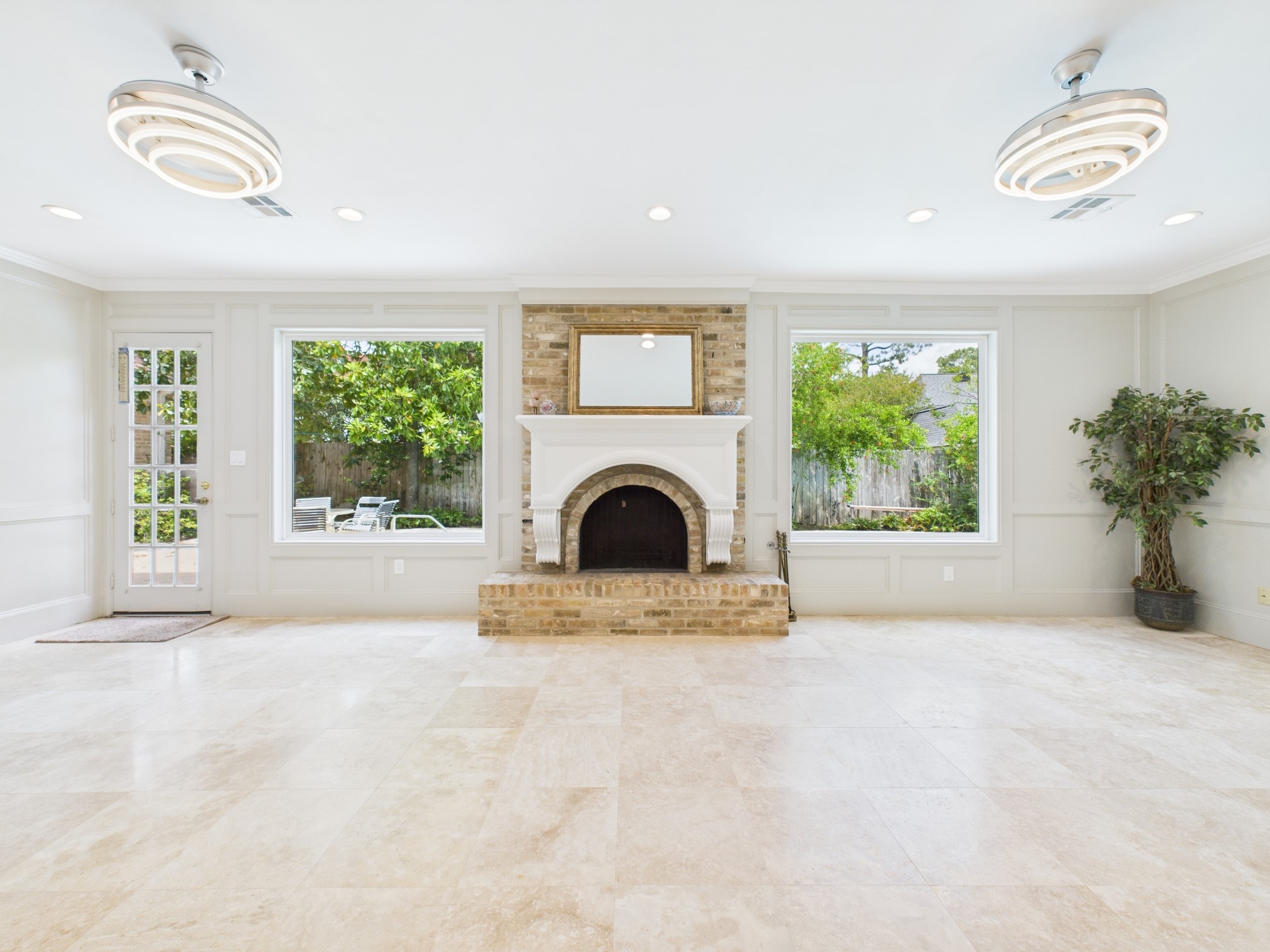 702 Daria Court Houston, TX 77079 - Photo 19 of 44 Gas Log Fireplace flanked by Windows along with Two Decorate Chandeliers that Double as Ceiling Fans