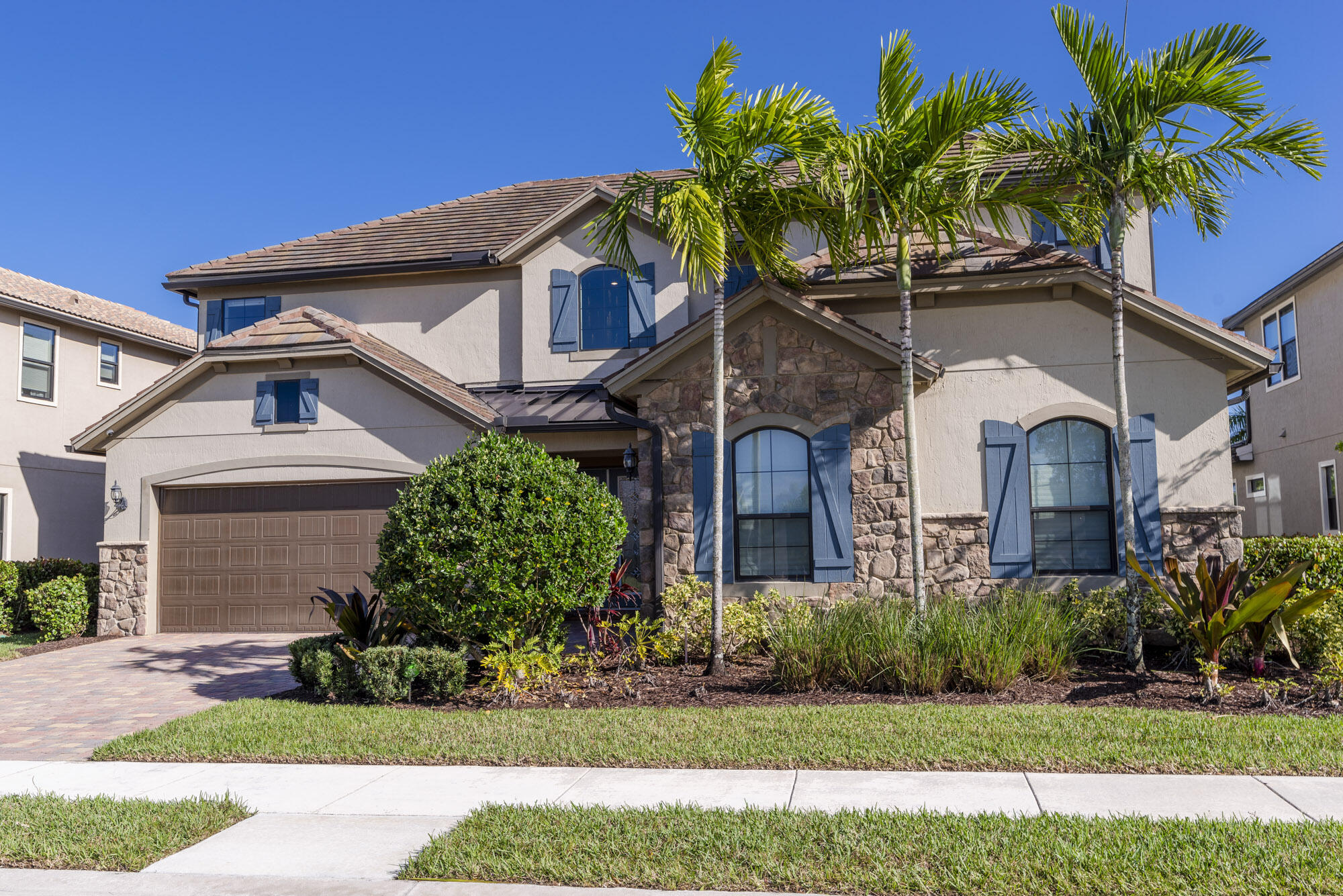 117 Croft Inlet Point Jupiter, FL 33478 - Photo 2 of 53 a front view of a house with a garden