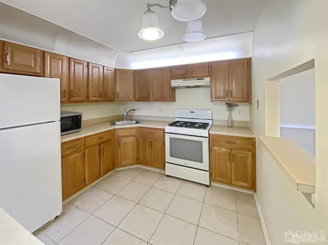 a kitchen with a white stove top oven and cabinets
