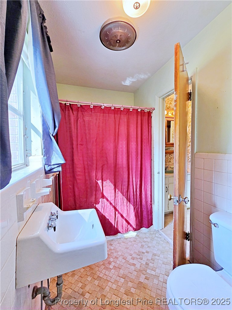 764 Old Vander Road Fayetteville, NC 28312 - Photo 25 of 50 a bathroom with a sink a toilet and shower curtain
