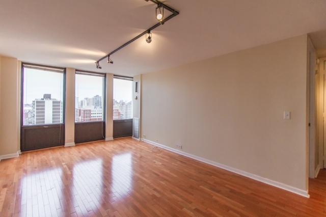 444 West Fullerton Parkway, Unit 1510 Chicago, IL 60614 - Photo 3 of 8 a view of an empty room with wooden floor and a window