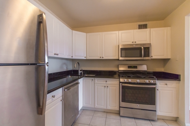 444 West Fullerton Parkway, Unit 1510 Chicago, IL 60614 - Photo 4 of 8 a kitchen with stainless steel appliances granite countertop a stove a microwave and a refrigerator