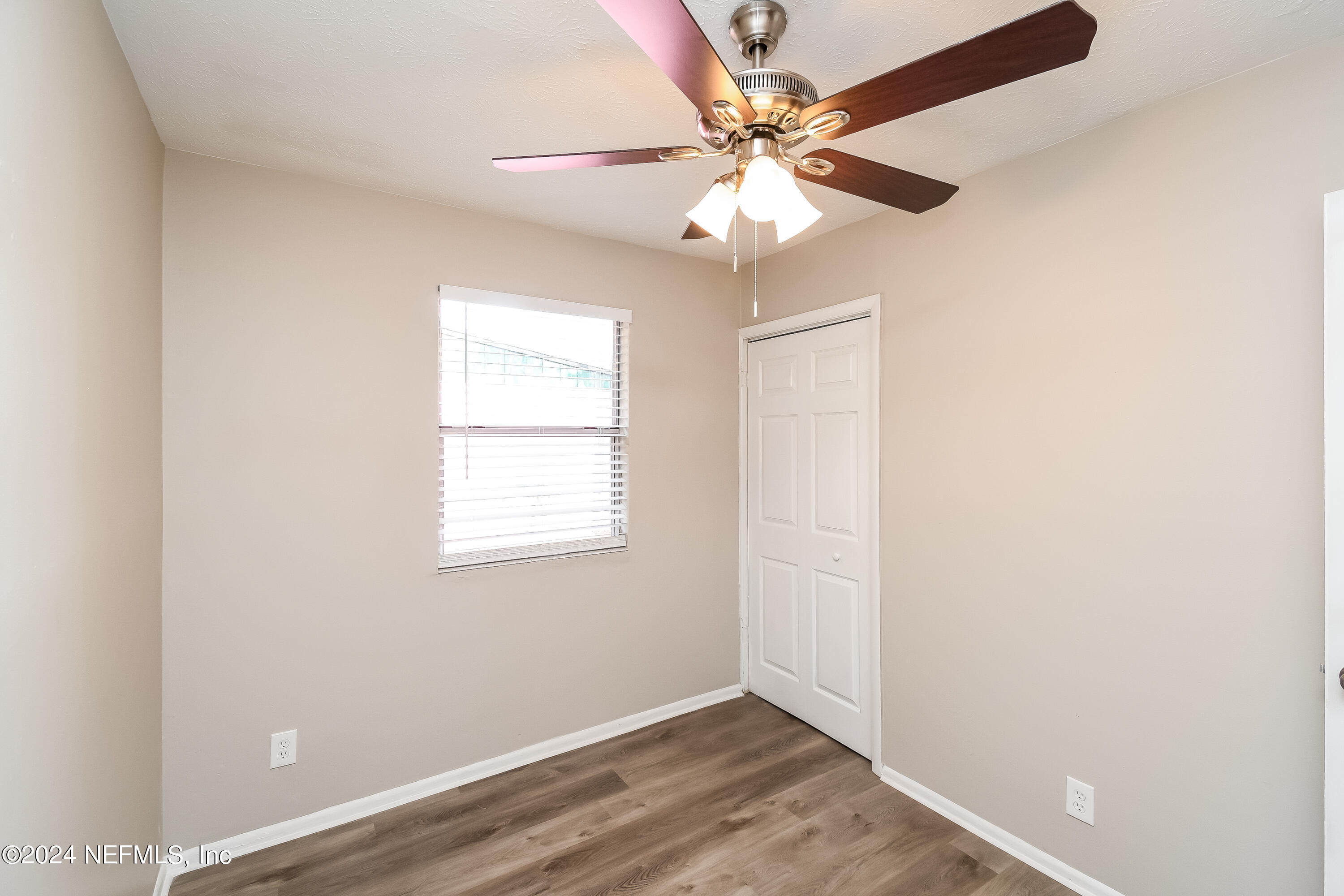 7217 Eudine Drive South Jacksonville, FL 32210 - Photo 12 of 16 an empty room with wooden floor fan and windows