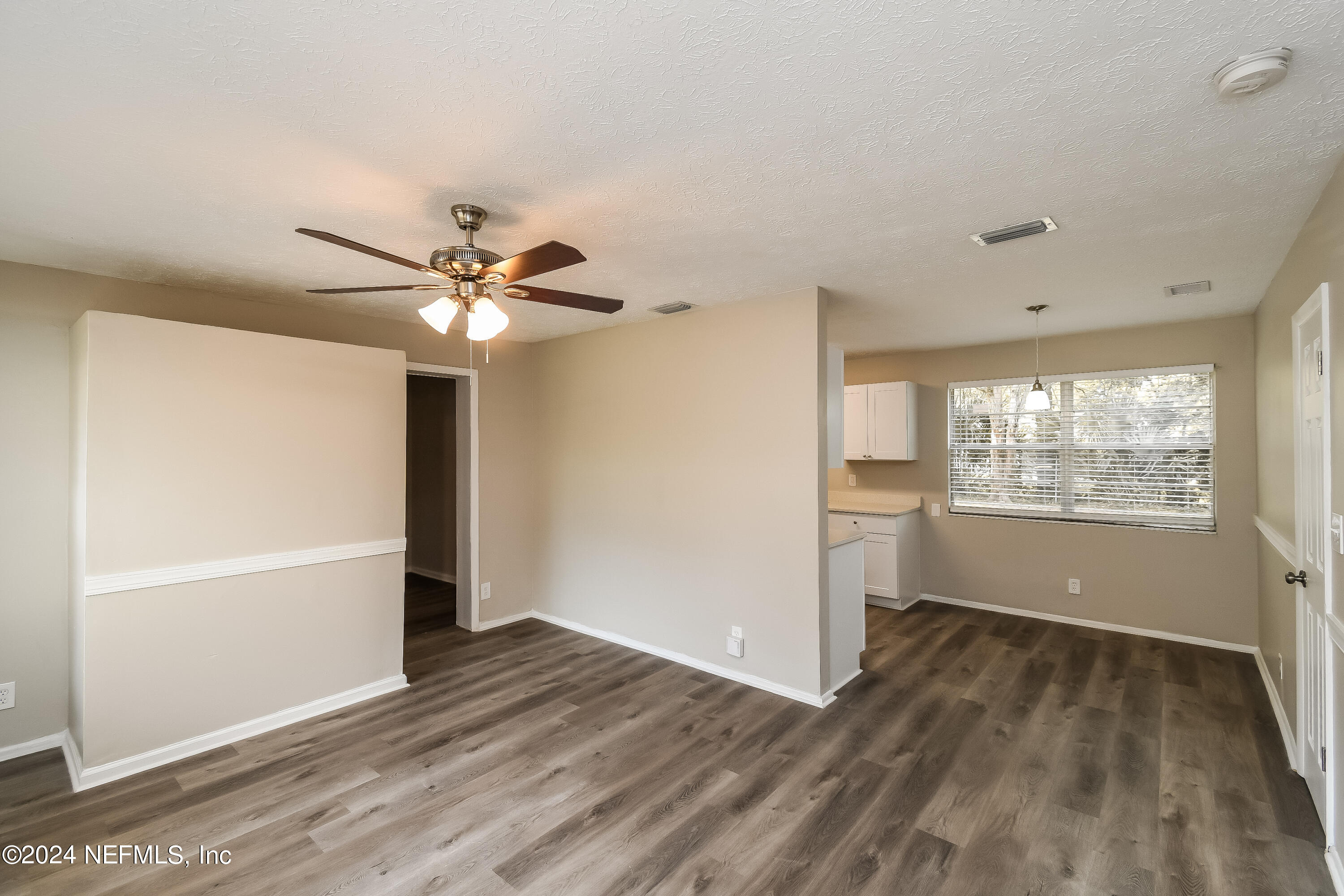 7217 Eudine Drive South Jacksonville, FL 32210 - Photo 3 of 16 a view of an empty room with wooden floor and a window