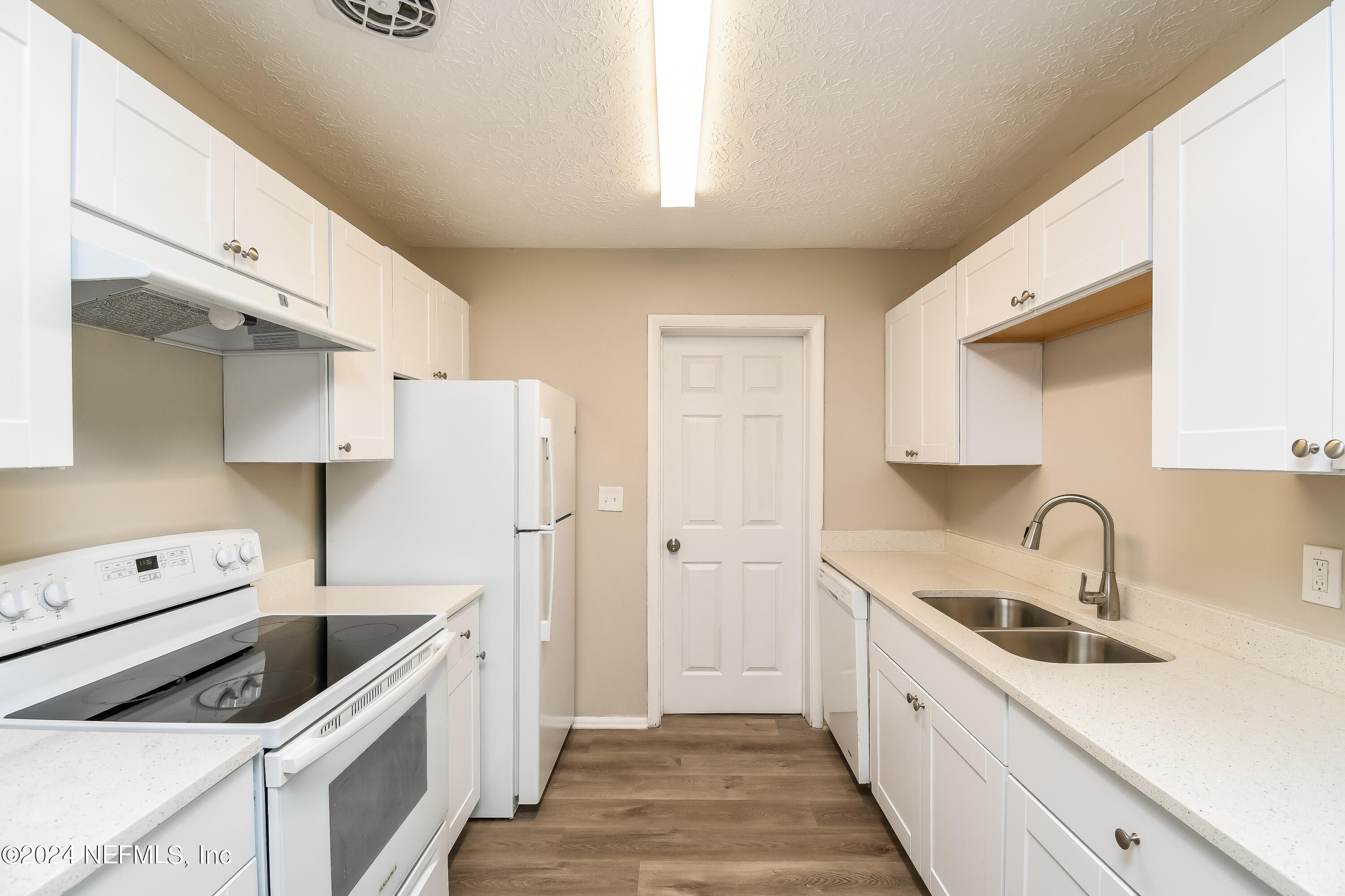 7217 Eudine Drive South Jacksonville, FL 32210 - Photo 4 of 16 a kitchen with white cabinets and white appliances
