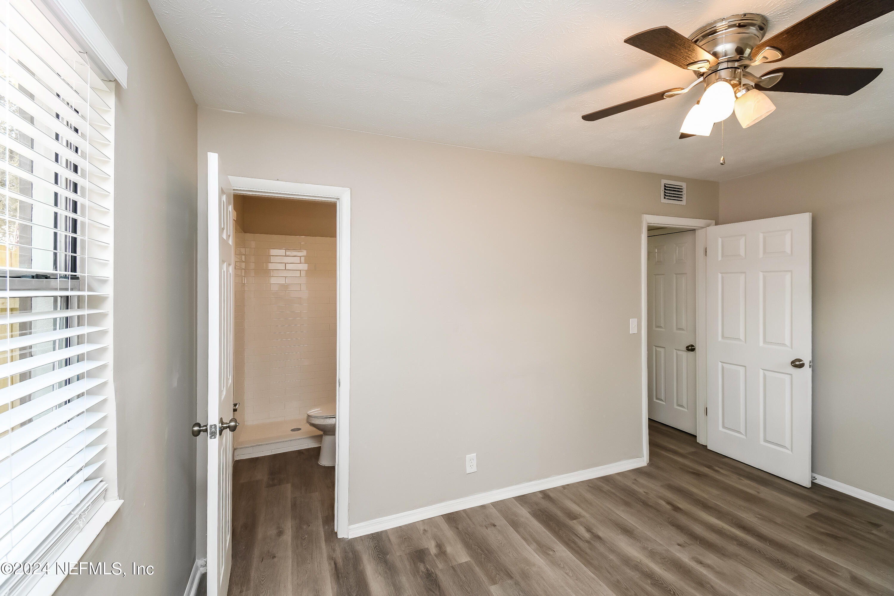 7217 Eudine Drive South Jacksonville, FL 32210 - Photo 7 of 16 wooden floor in an empty room with a window