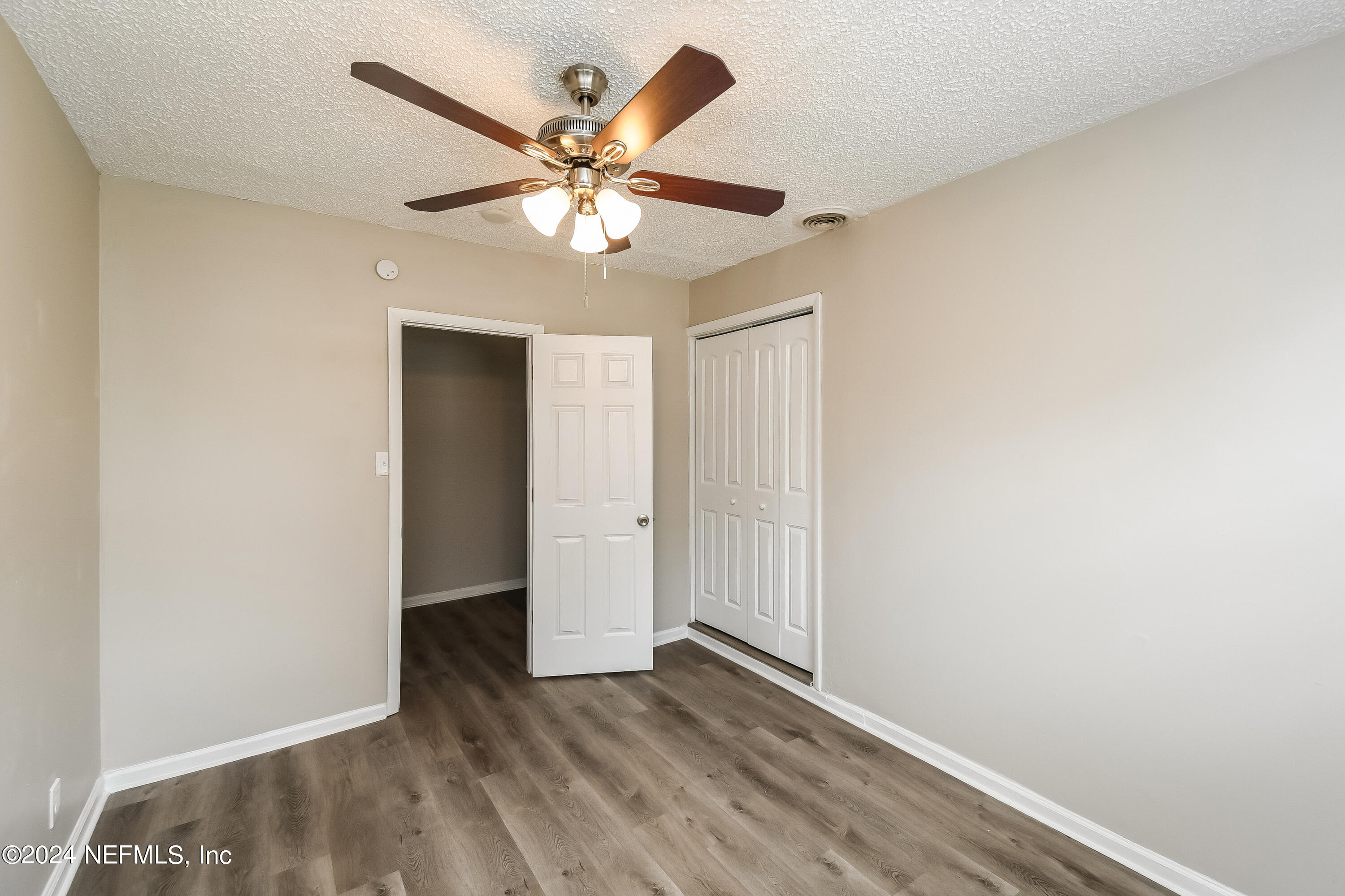 7217 Eudine Drive South Jacksonville, FL 32210 - Photo 9 of 16 an empty room with wooden floor and fan