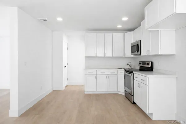 a kitchen with granite countertop white cabinets and white appliances