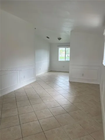 an empty room with white walls and windows