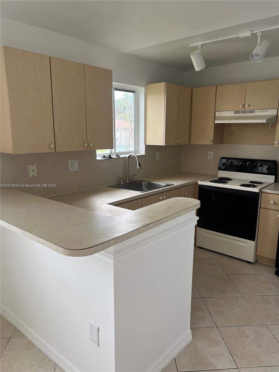 2921 Southeast 12th Road, Unit 20656 Homestead, FL 33035 - Photo 5 of 9 a kitchen with stainless steel appliances granite countertop a sink a stove and a refrigerator