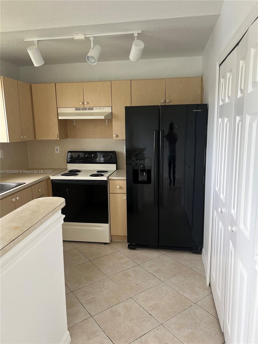 2921 Southeast 12th Road, Unit 20656 Homestead, FL 33035 - Photo 6 of 9 a kitchen with stainless steel appliances granite countertop a refrigerator and a stove