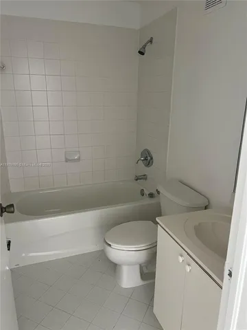 a white toilet sitting next to a bath tub