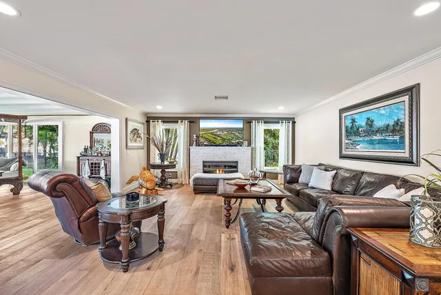 a living room with furniture a fireplace and a floor to ceiling window