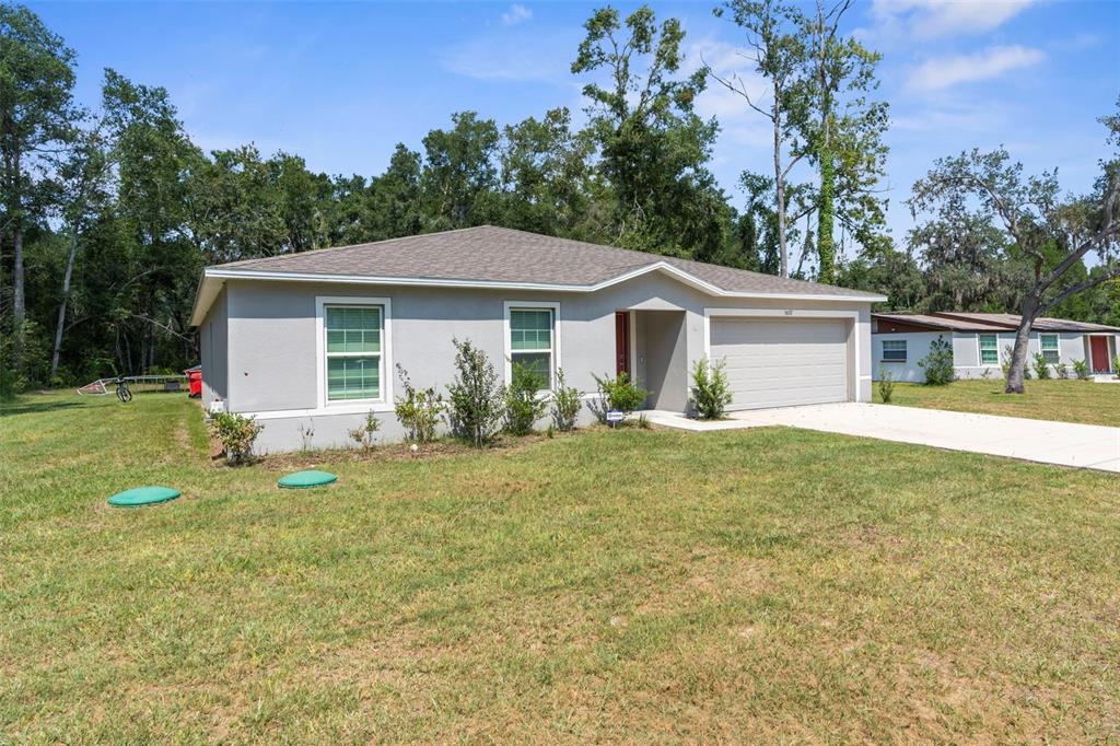 5637 East Tangelo Lane Inverness, FL 34453 - Photo 3 of 23 a view of a yard in front of a house with plants and large tree