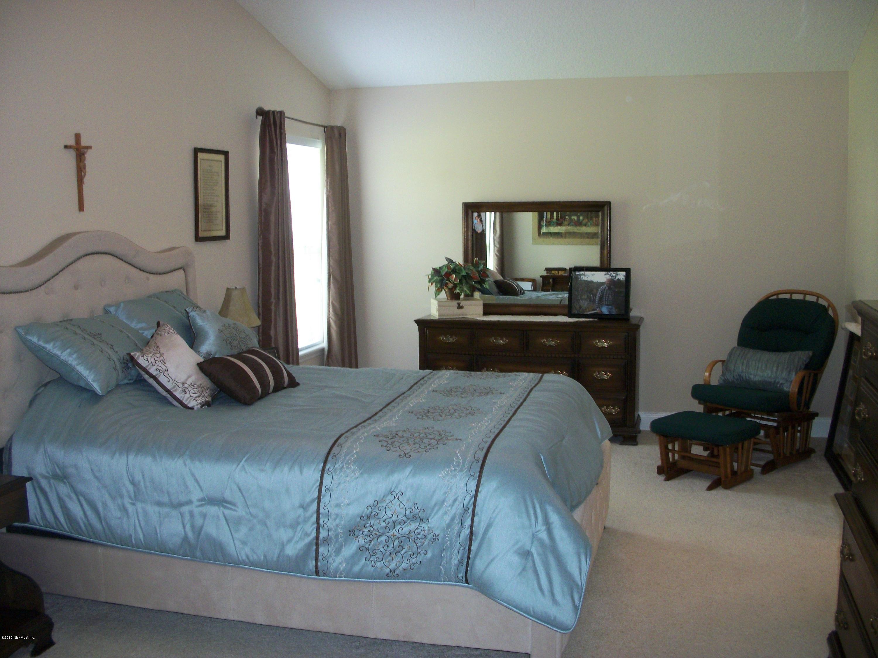 96057 Maranatha Road Yulee, FL 32097 - Photo 11 of 25 a bedroom with a bed and a chair in it