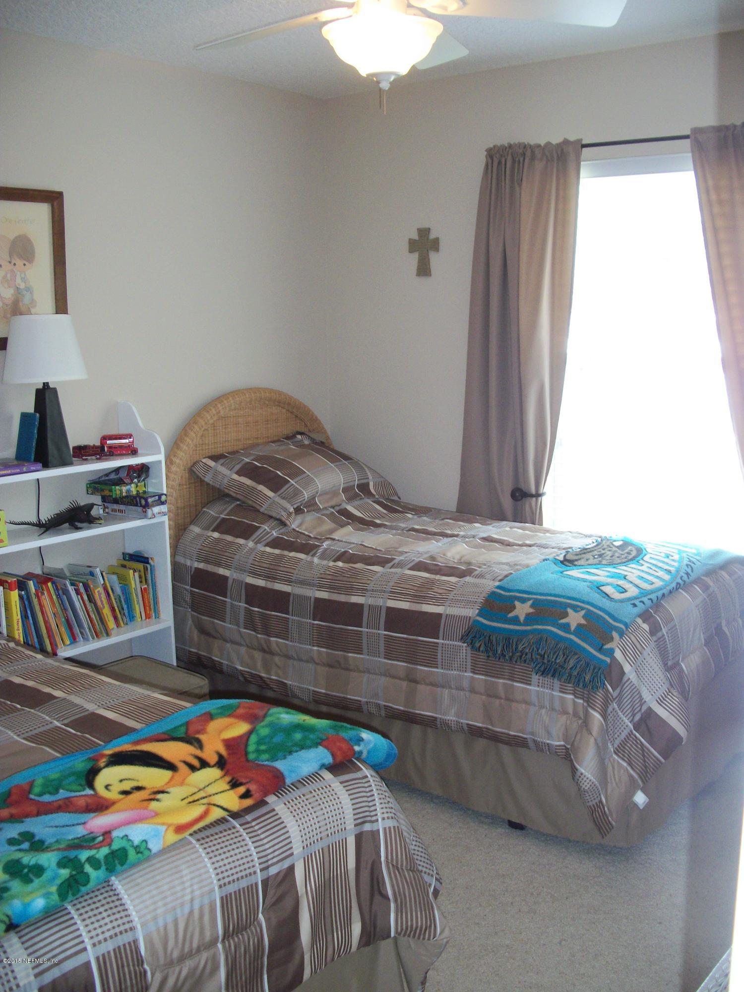 96057 Maranatha Road Yulee, FL 32097 - Photo 15 of 25 a bedroom with a bed and a book shelf