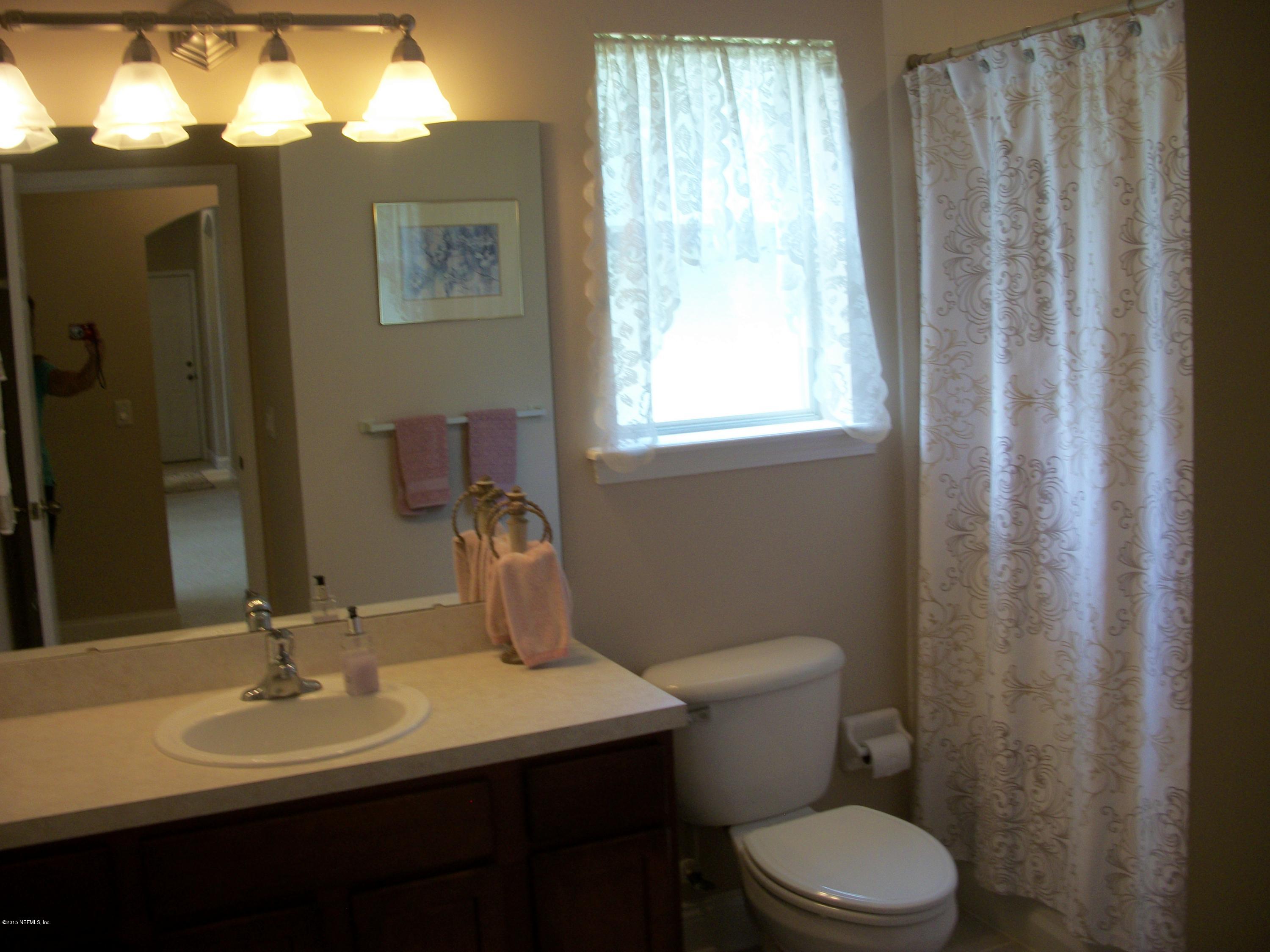 96057 Maranatha Road Yulee, FL 32097 - Photo 16 of 25 a bathroom with a toilet a sink and a large mirror