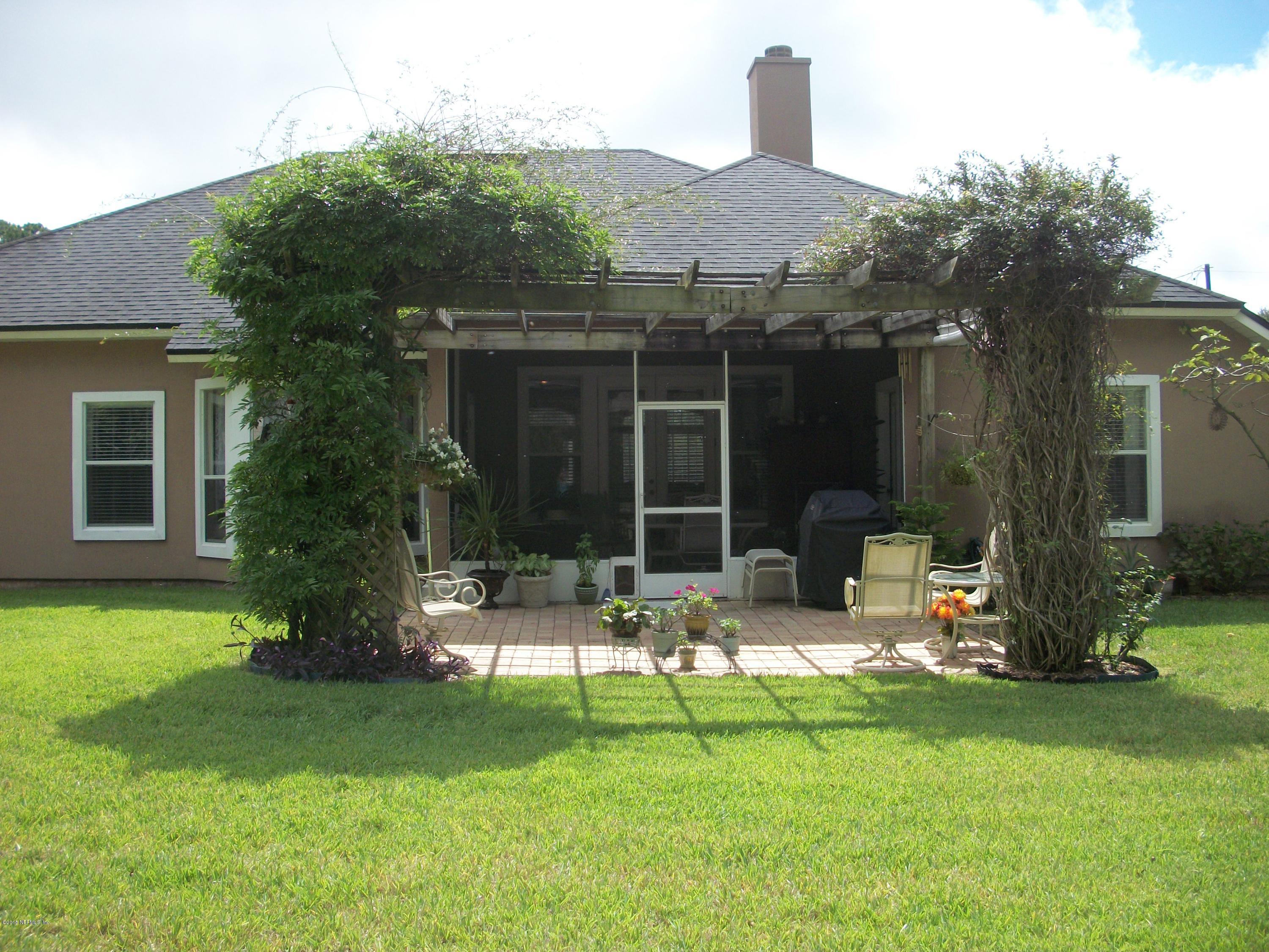 96057 Maranatha Road Yulee, FL 32097 - Photo 19 of 25 a view of a house with backyard sitting area and garden