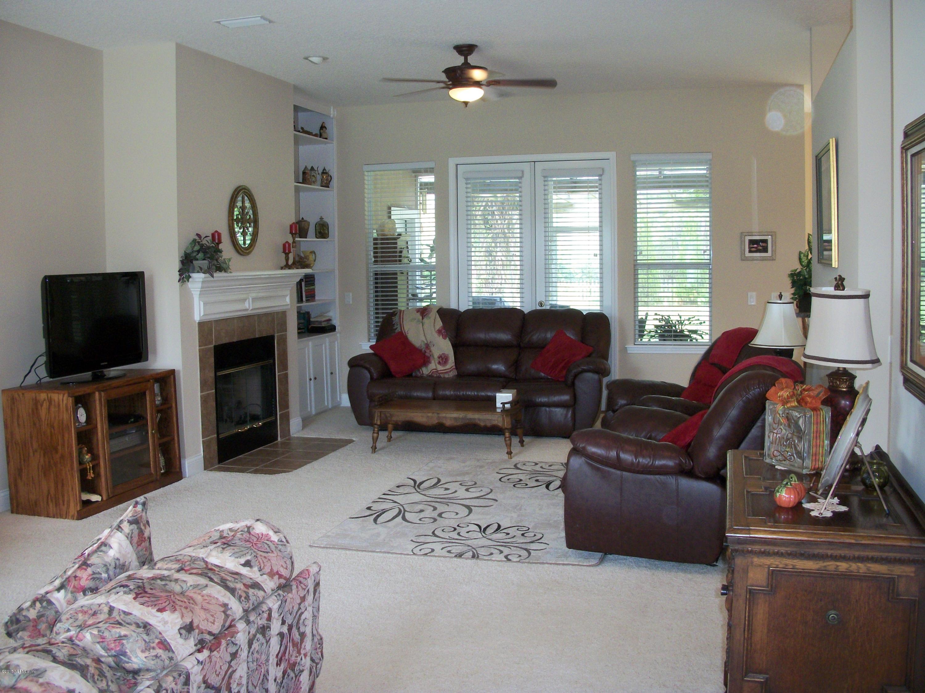 96057 Maranatha Road Yulee, FL 32097 - Photo 3 of 25 a living room with furniture a fireplace and a flat screen tv
