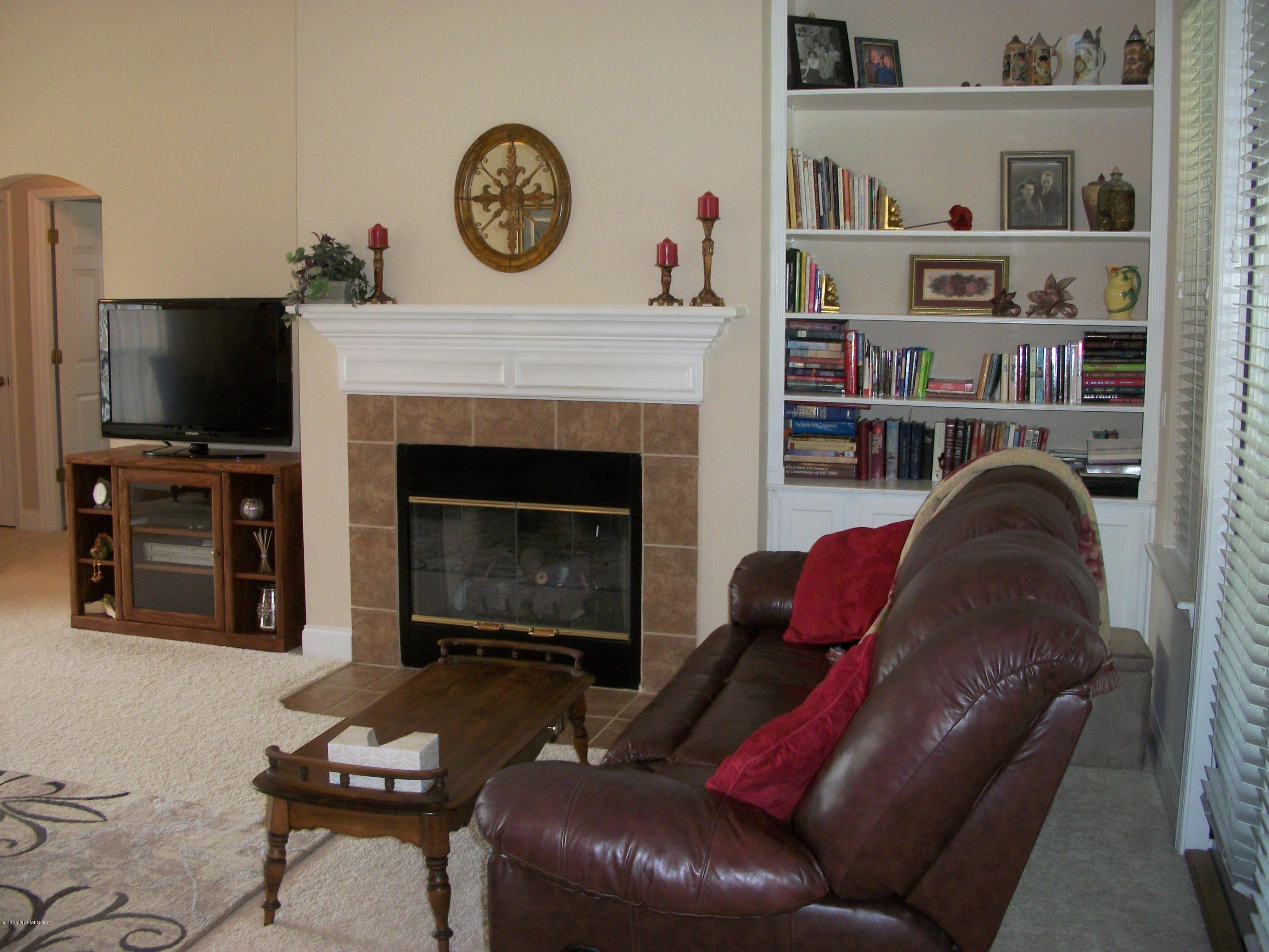 96057 Maranatha Road Yulee, FL 32097 - Photo 4 of 25 a living room with furniture a flat screen tv and a fireplace